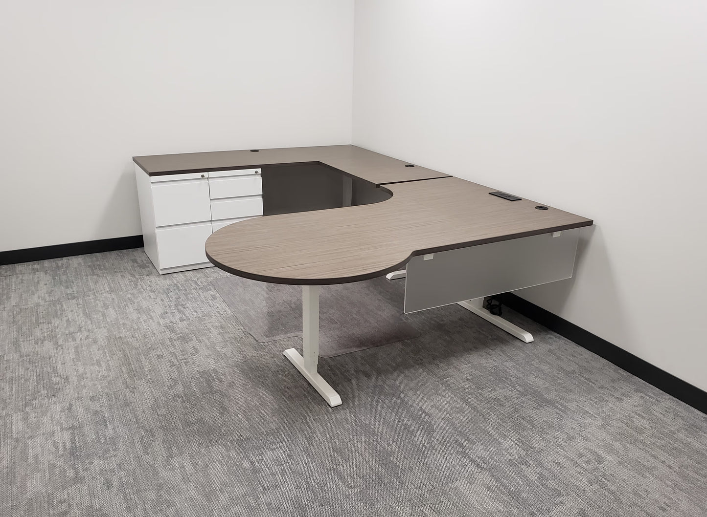 Custom L-shaped desk with height-adjustable section and overhead storage by gen2