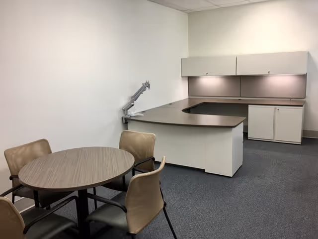 Custom office desk with height-adjustable base, overhead storage, and dark finish by gen2